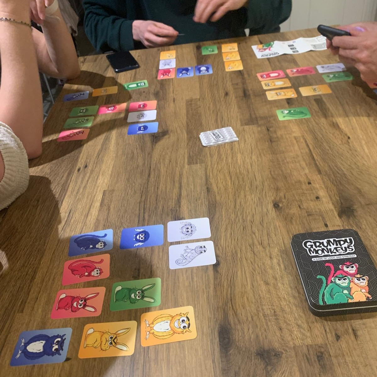 Grumpy Monkeys card game in play on a table with players mid game.